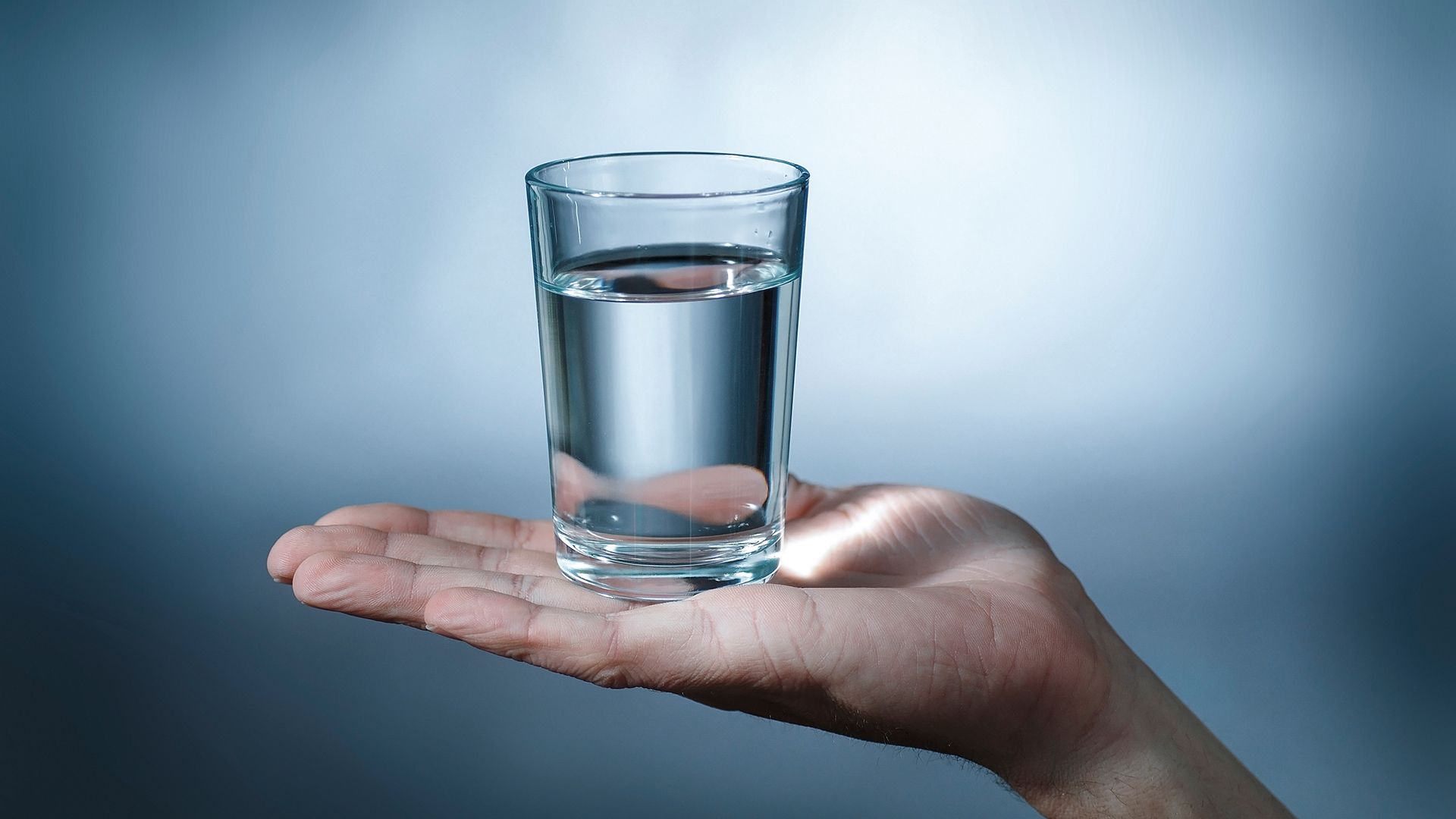 Ein gefülltes Wasserglas steht mittig auf einer ausgestreckten Hand vor neutral-blauem Hintergrund. Das Motiv visualisiert Vertrauen, Hygiene und verlässliche Trinkwasseranalytik. Ideal zur Darstellung unabhängiger Prüf- und Laborleistungen für Wasserversorger, Gebäudebetreiber und regulierte Anwendungen. Ein gefülltes Wasserglas steht mittig auf einer ausgestreckten Hand vor neutral-blauem Hintergrund. Das Motiv visualisiert Vertrauen, Hygiene und verlässliche Trinkwasseranalytik. Ideal zur Darstellung unabhängiger Prüf- und Laborleistungen für Wasserversorger, Gebäudebetreiber und regulierte Anwendungen.
